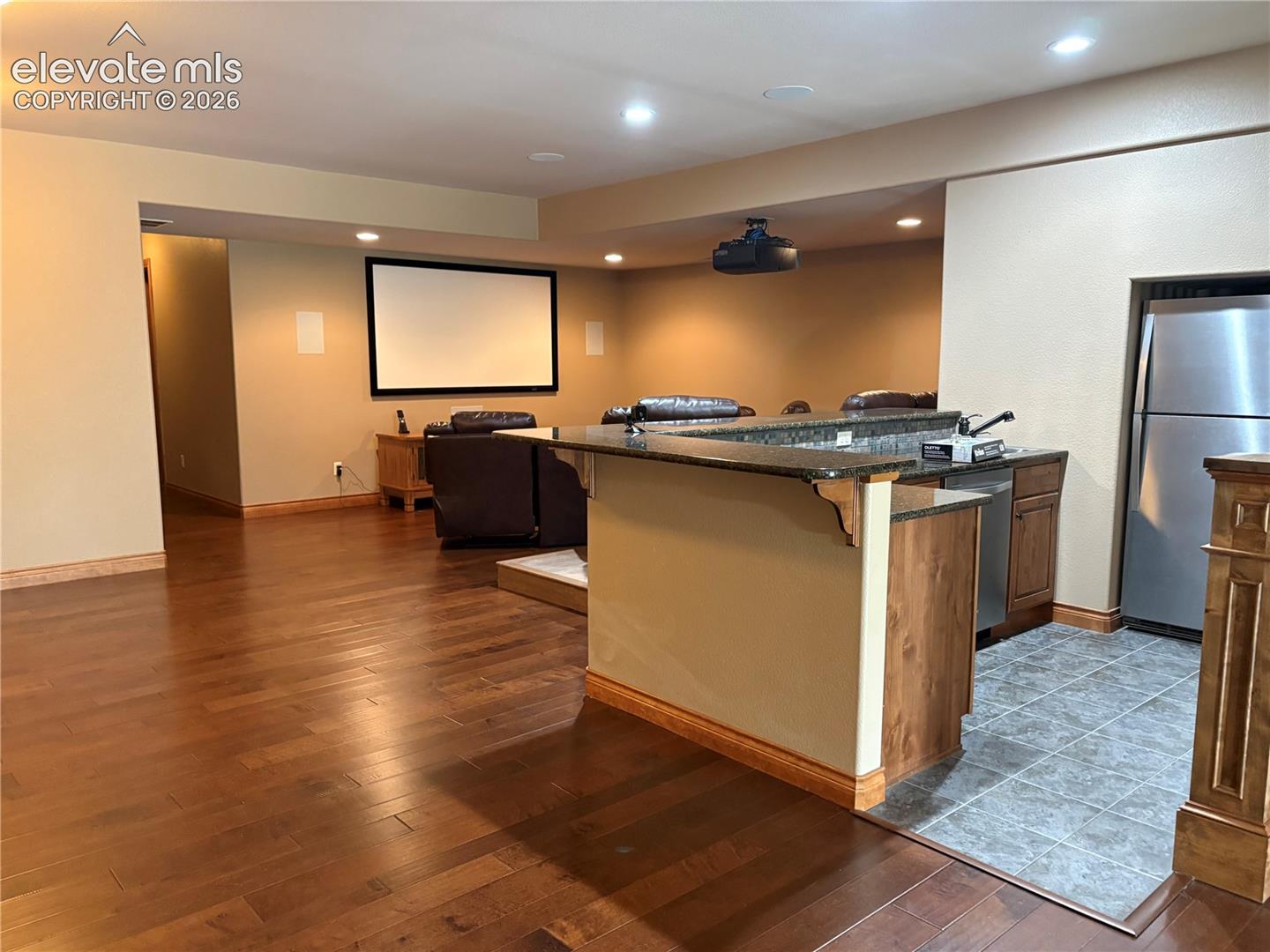 Lower level kitchenette with stainless steel dishwasher and refrigerator 