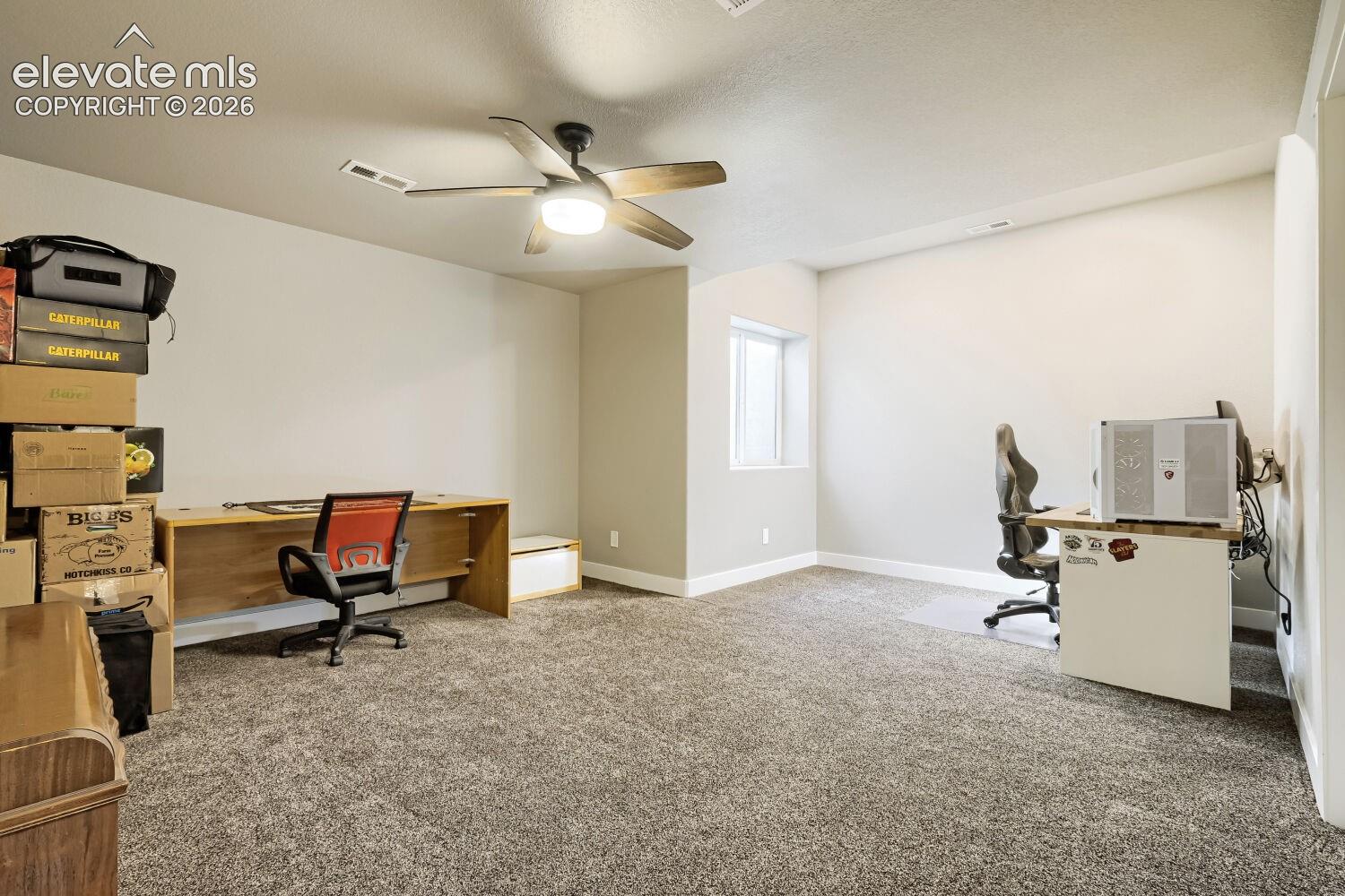 Recessed window, textured carpeting, ceiling fan with integrated lighting, and neutral wall tones