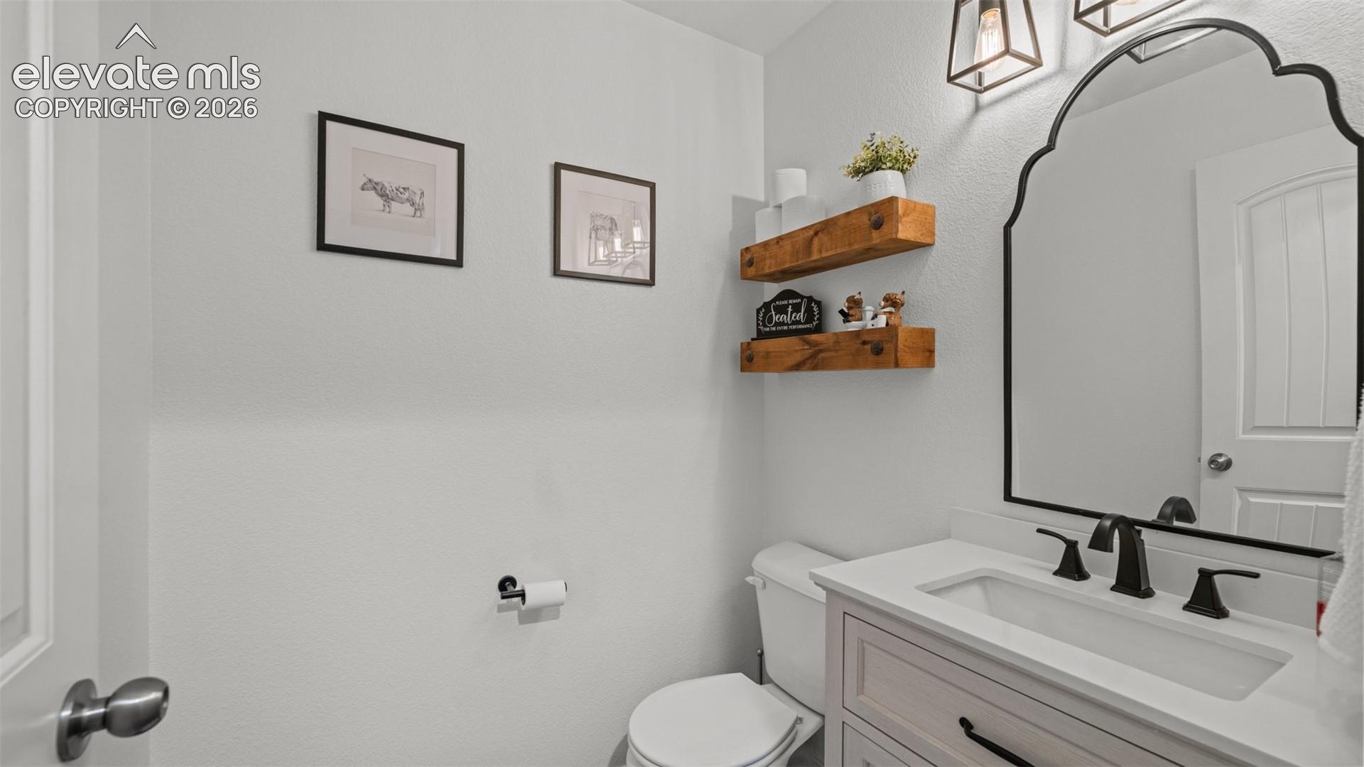 Bathroom featuring a vanity with a white countertop and undermount sink, matte black faucet, and a black-framed ornate mirror