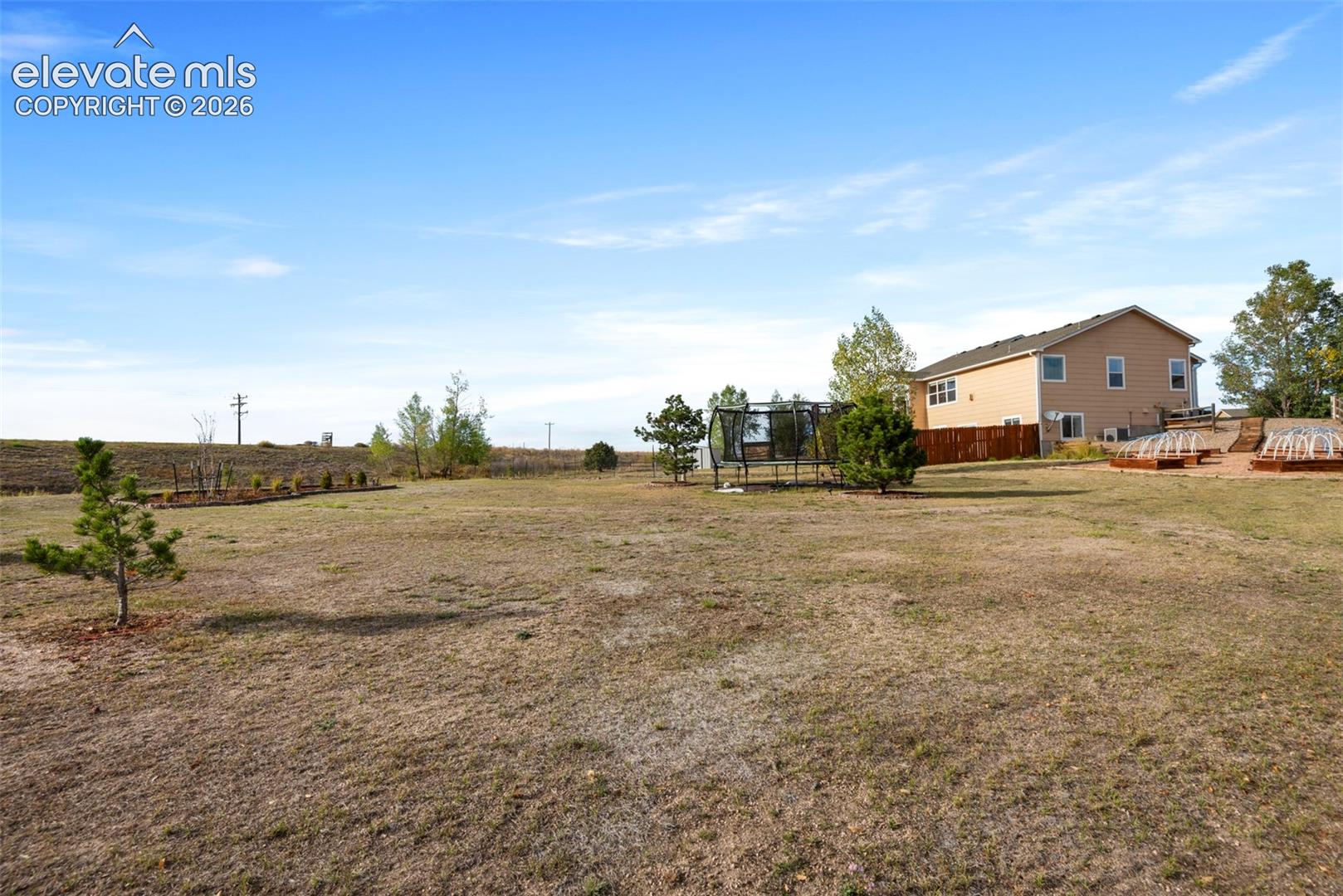 Expansive Acreage Backyard, Large Open Space, Mature trees, Raised Garden Beds, and Wood Privacy Fencing