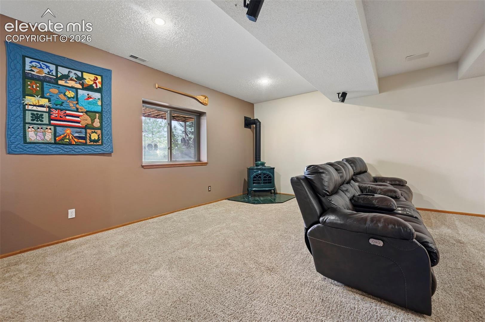 Basement media room/2nd family room, carpeted room featuring a window, recessed lighting, and a freestanding stove with a dark green finish