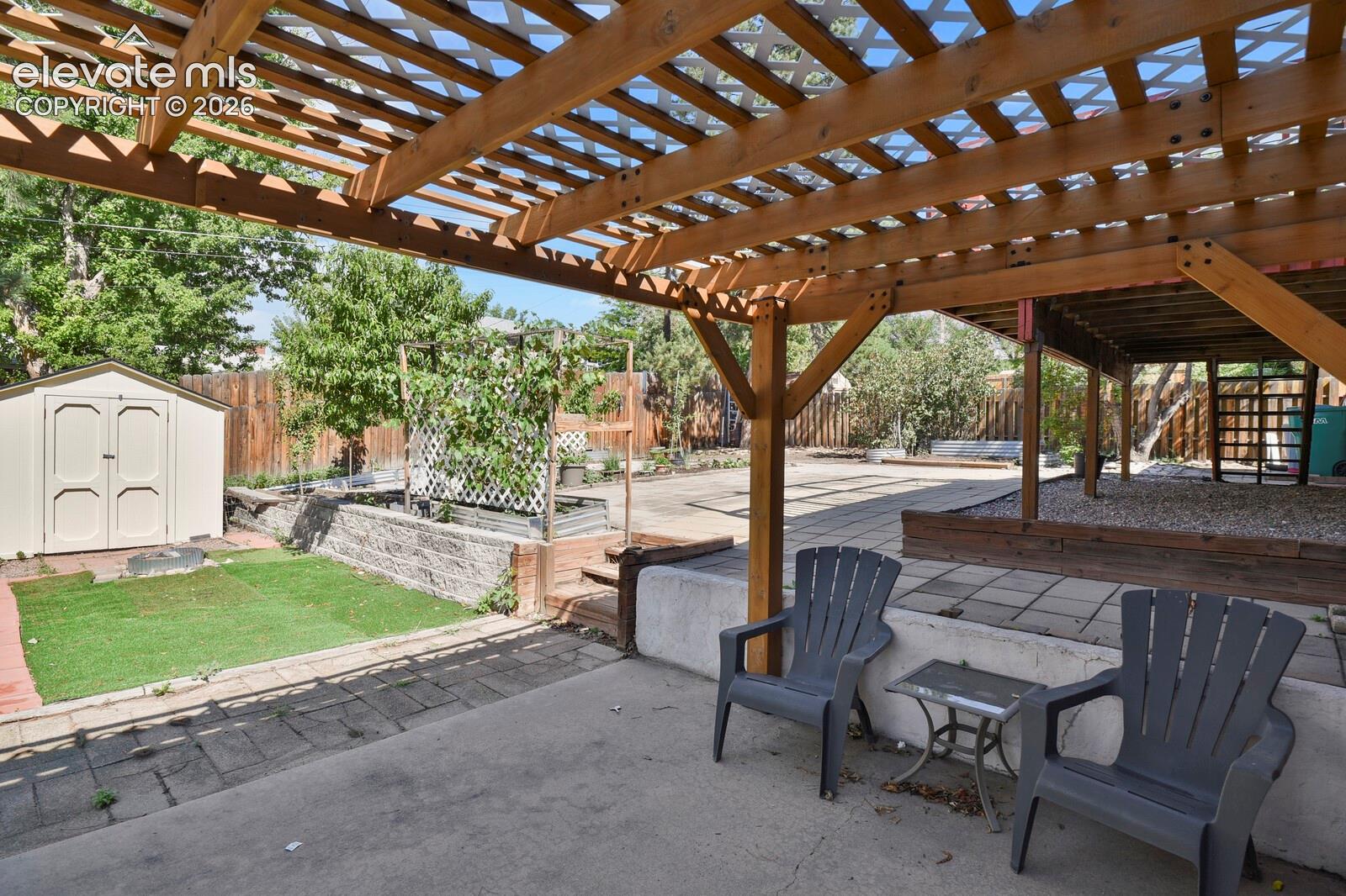 Expansive covered patio with lattice pergola overhead, providing dappled shade and architectural interest