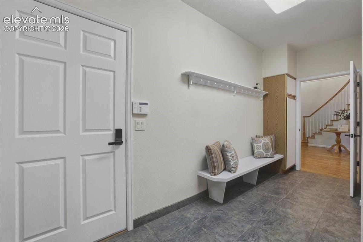 Six-panel interior door with matte black hardware, tiled flooring, wood-finish built-in cabinetry,