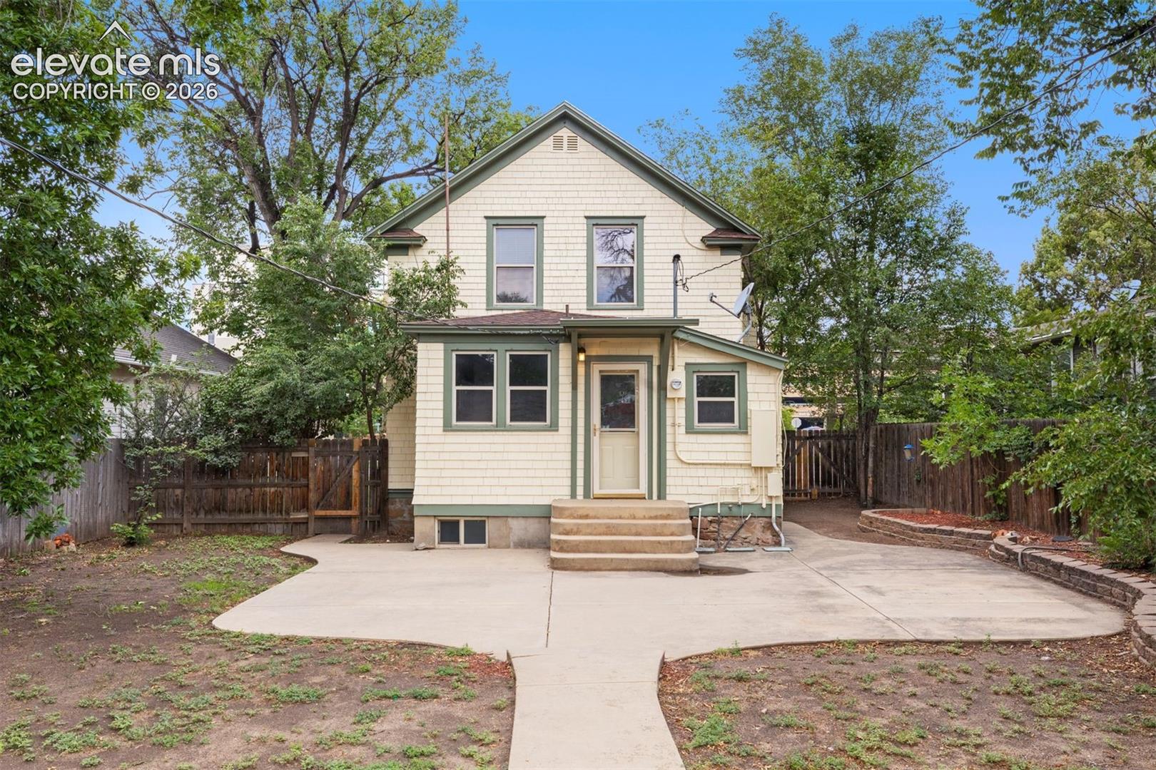 Back of home with large concrete patio