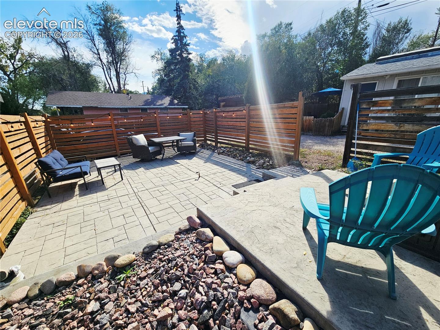 Multi-tiered stamped concrete patio with privacy fence between units