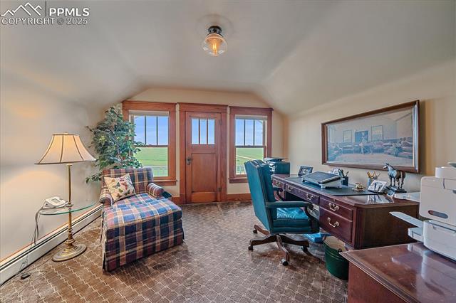 Home office featuring lofted ceiling, baseboard heating, and carpet floors