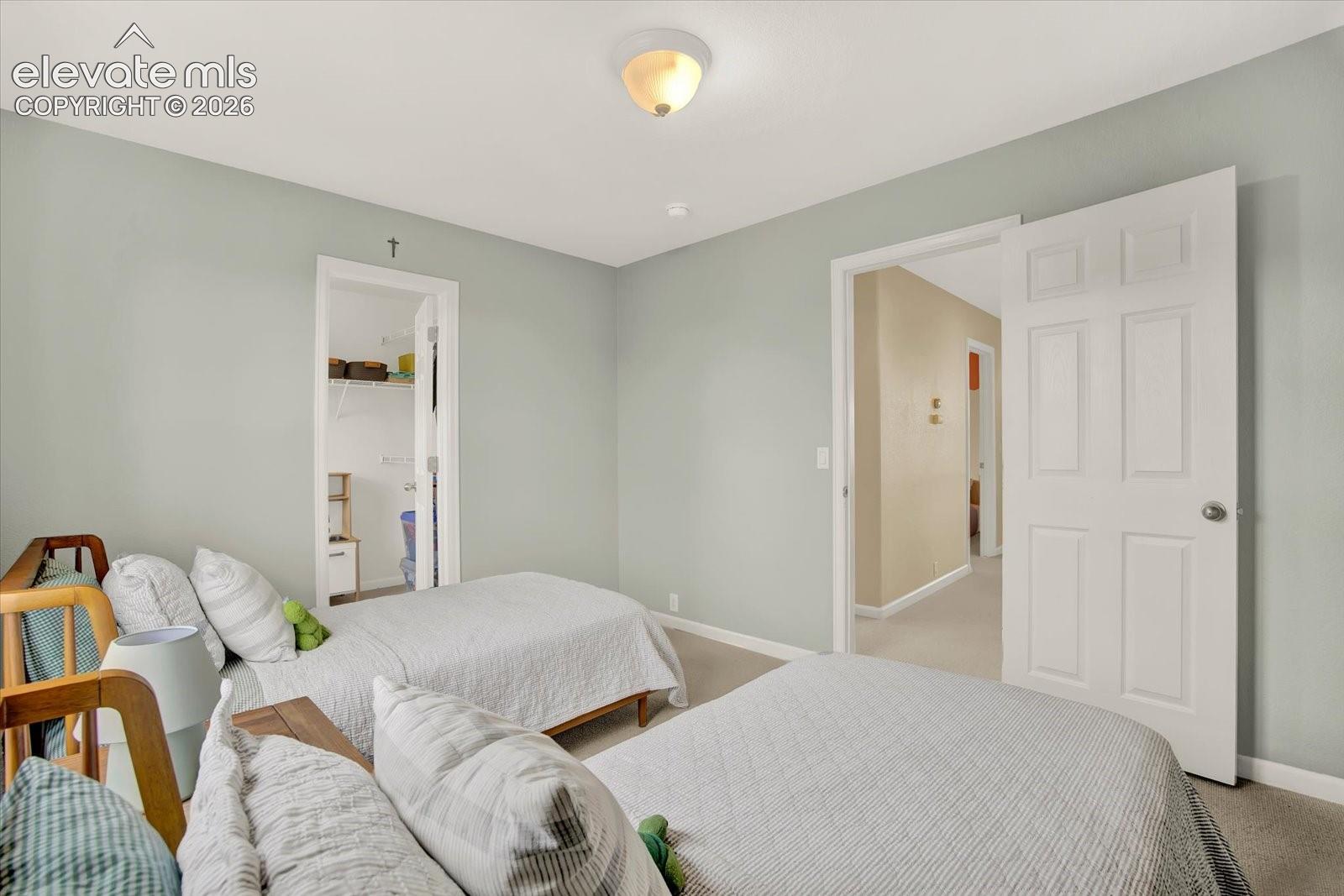 Neutral-toned walls, flush-mount ceiling lighting, six-panel interior doors, and carpeted flooring