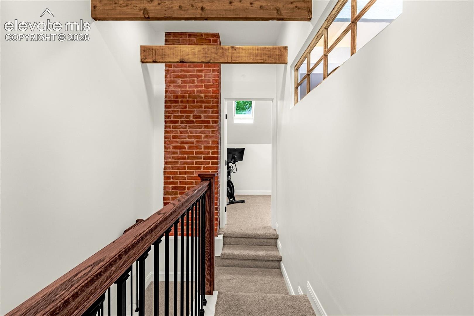 Upstairs hallway with exposed beams and vintage window