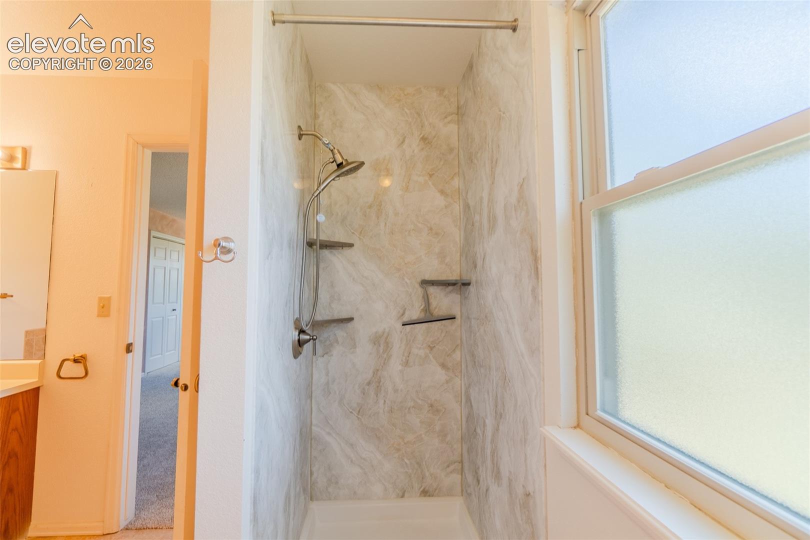 Shower with integrated shelving, handheld shower, and brushed nickel fixtures