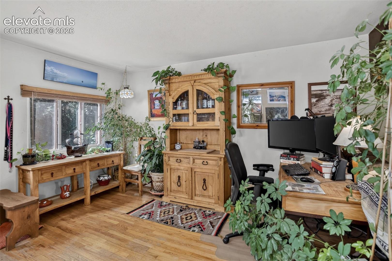 Wood-finish flooring with abundant natural light from a multi-pane window