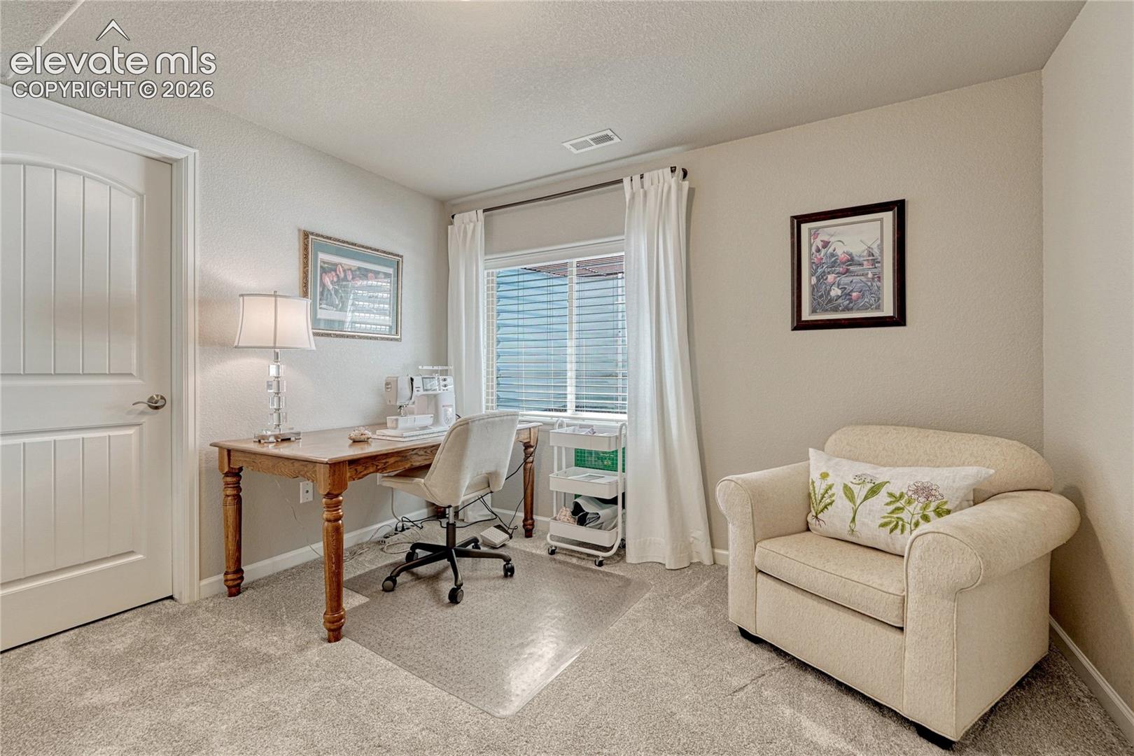 A bright second basement bedroom offers flexibility with natural light, comfortable flooring, and space for both sleeping and workspace needs.
