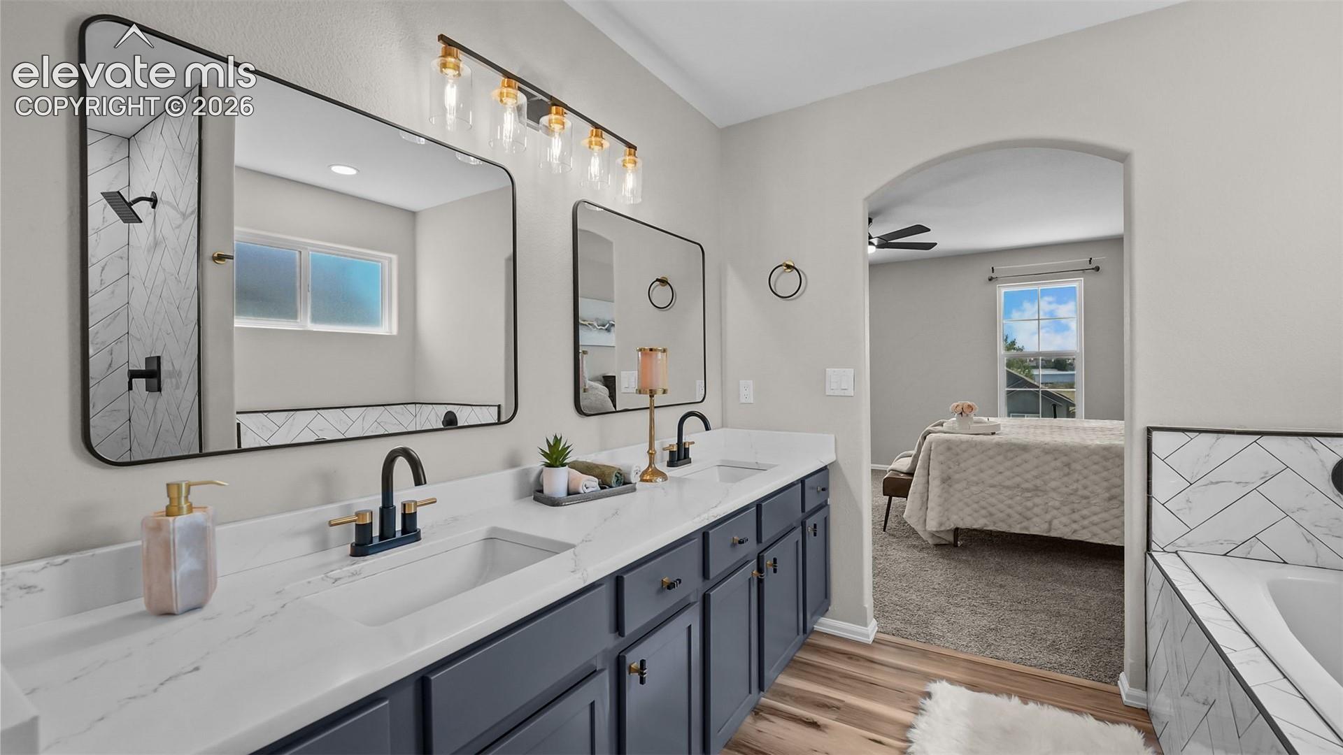 Double vanity with white countertops, dark cabinetry, and matte black fixtures