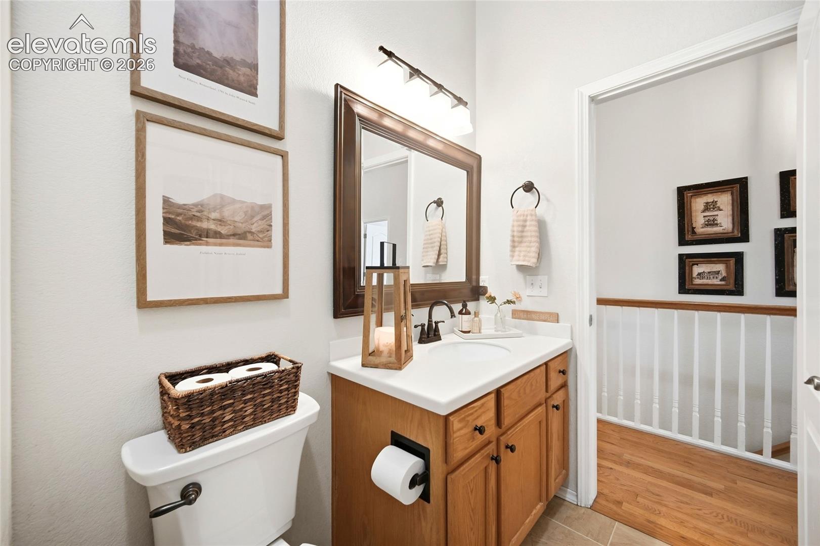 Bathroom vanity with a single basin, light wood-finish cabinetry, and a dark-framed mirror