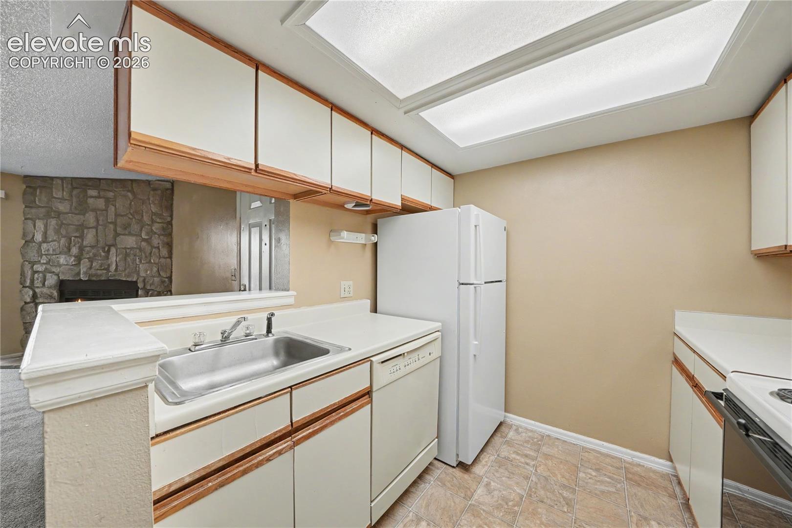 Kitchen with white appliances and laminate counters