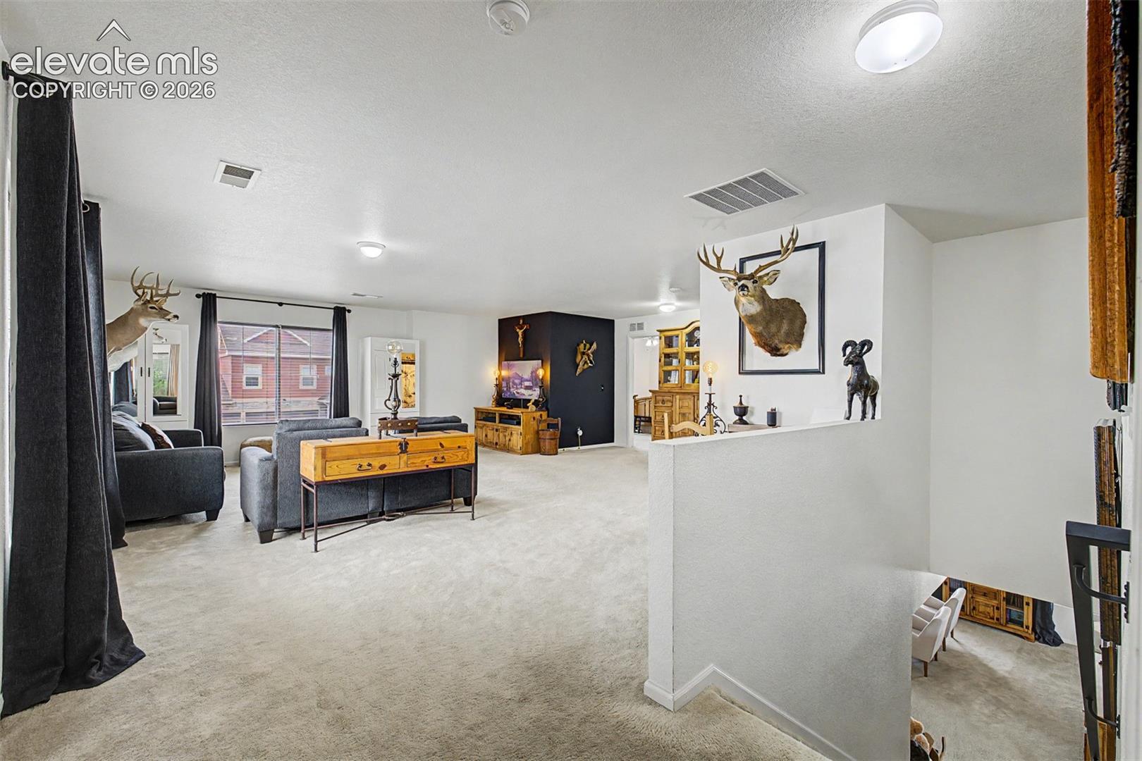 At the top of the stairs, a generous loft space opens up with room to roam, a flexible bonus area already styled for both lounging and display.