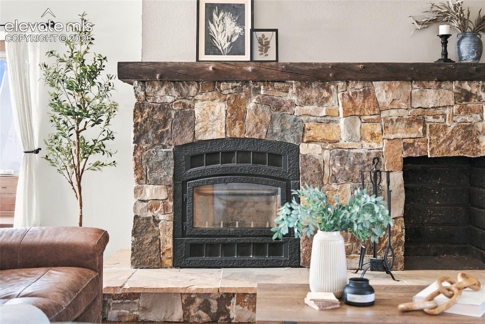 Stone-faced fireplace with a substantial wood mantel and a metal firebox insert