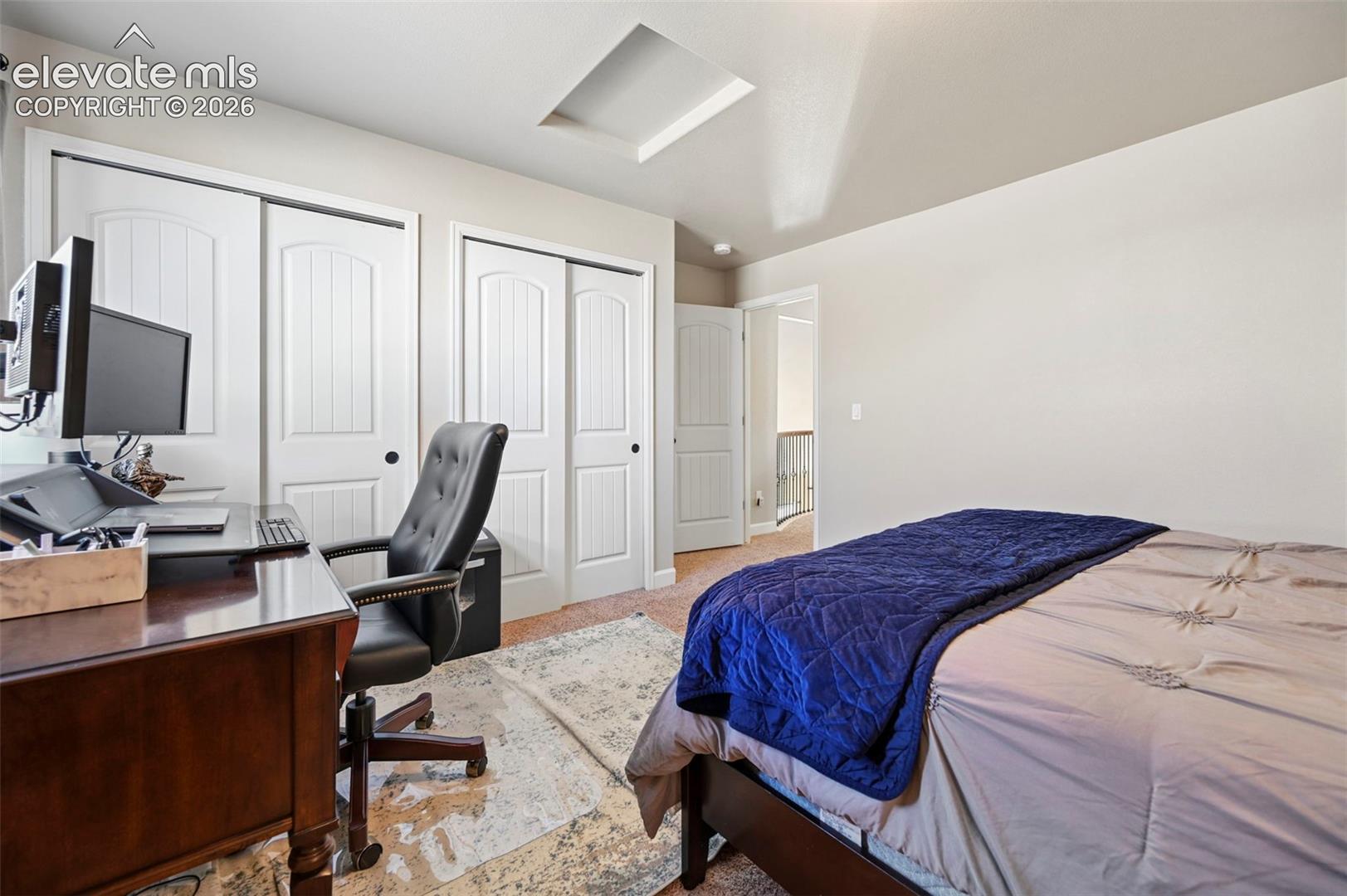 Recessed ceiling feature, white sliding closet doors, ceiling light fixture, neutral wall paint, carpet flooring