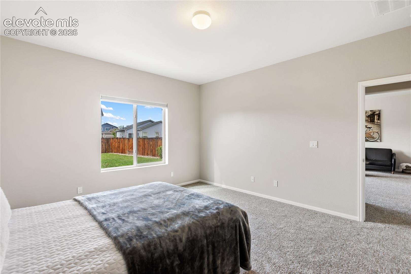 Spacious primary bedroom with room darkening shades