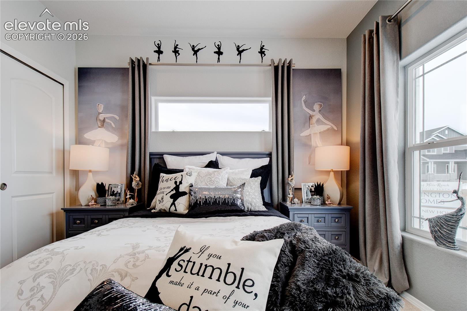 Bedroom featuring a horizontal clerestory window, white interior door with brushed metal hardware, and a single-hung window with a multi-pane upper sash