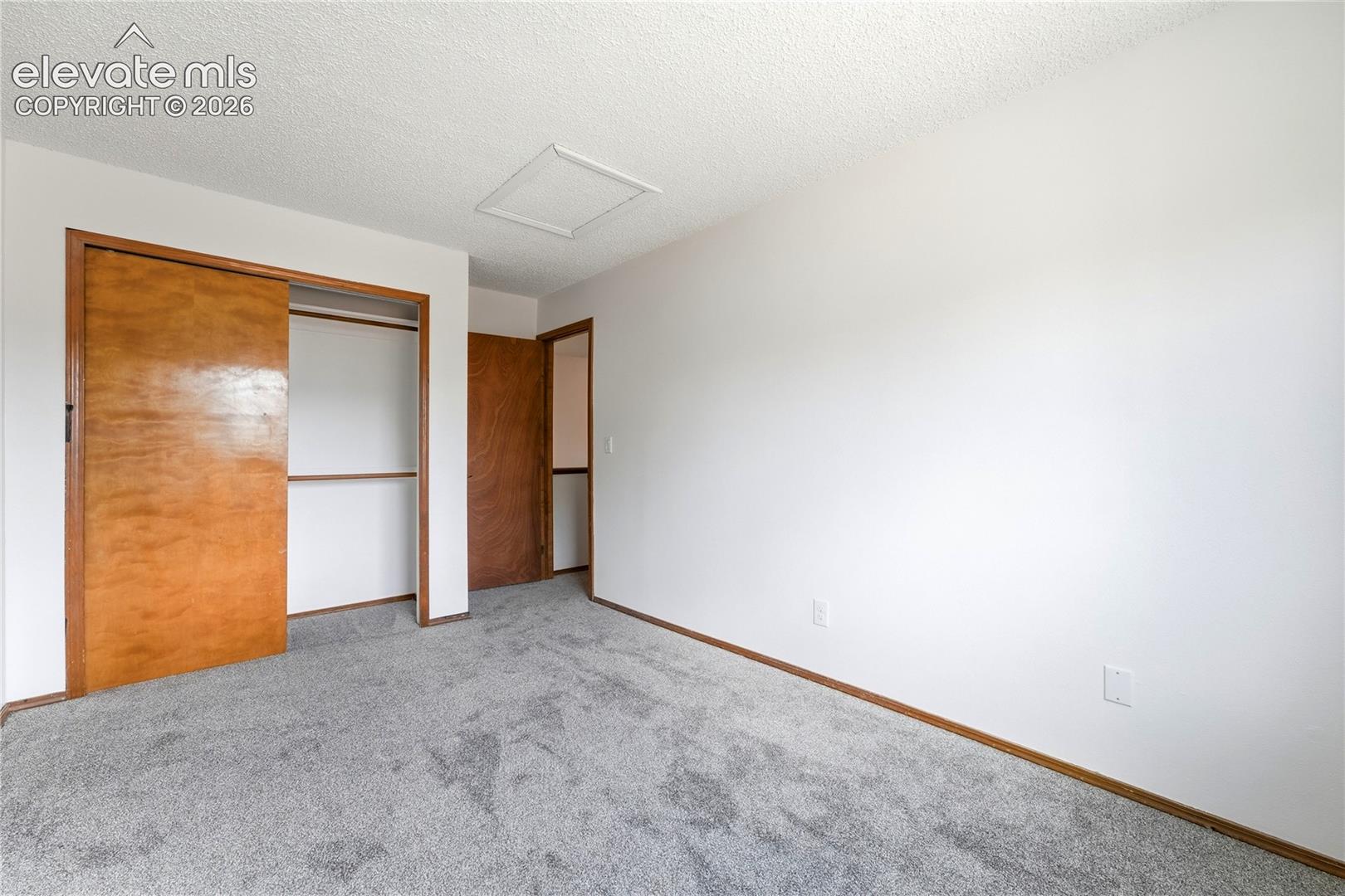 Neutral wall finish, carpeted flooring, faux wood vinyl window