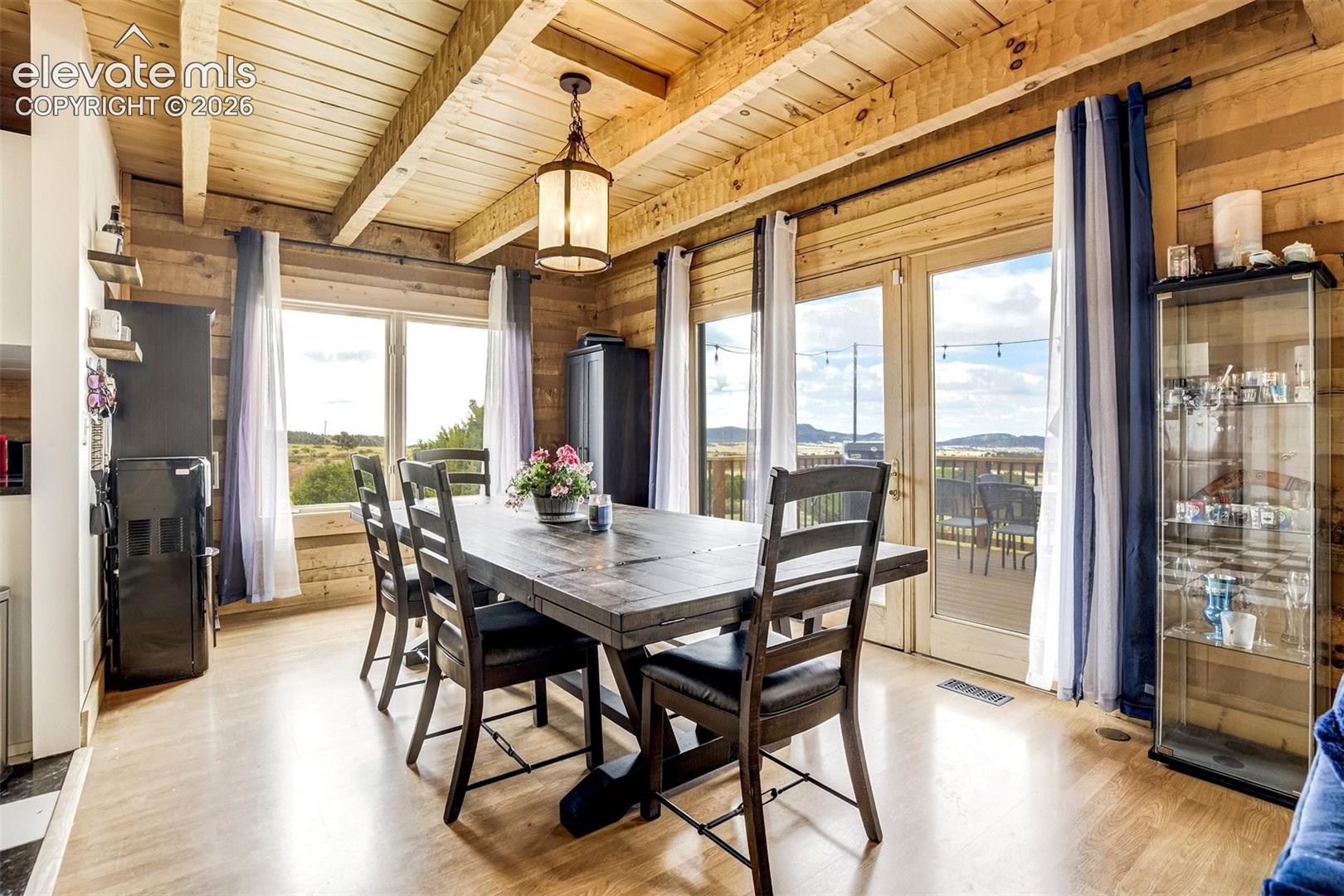 Dining area featuring extensive wood-paneled walls and exposed beam ceilings