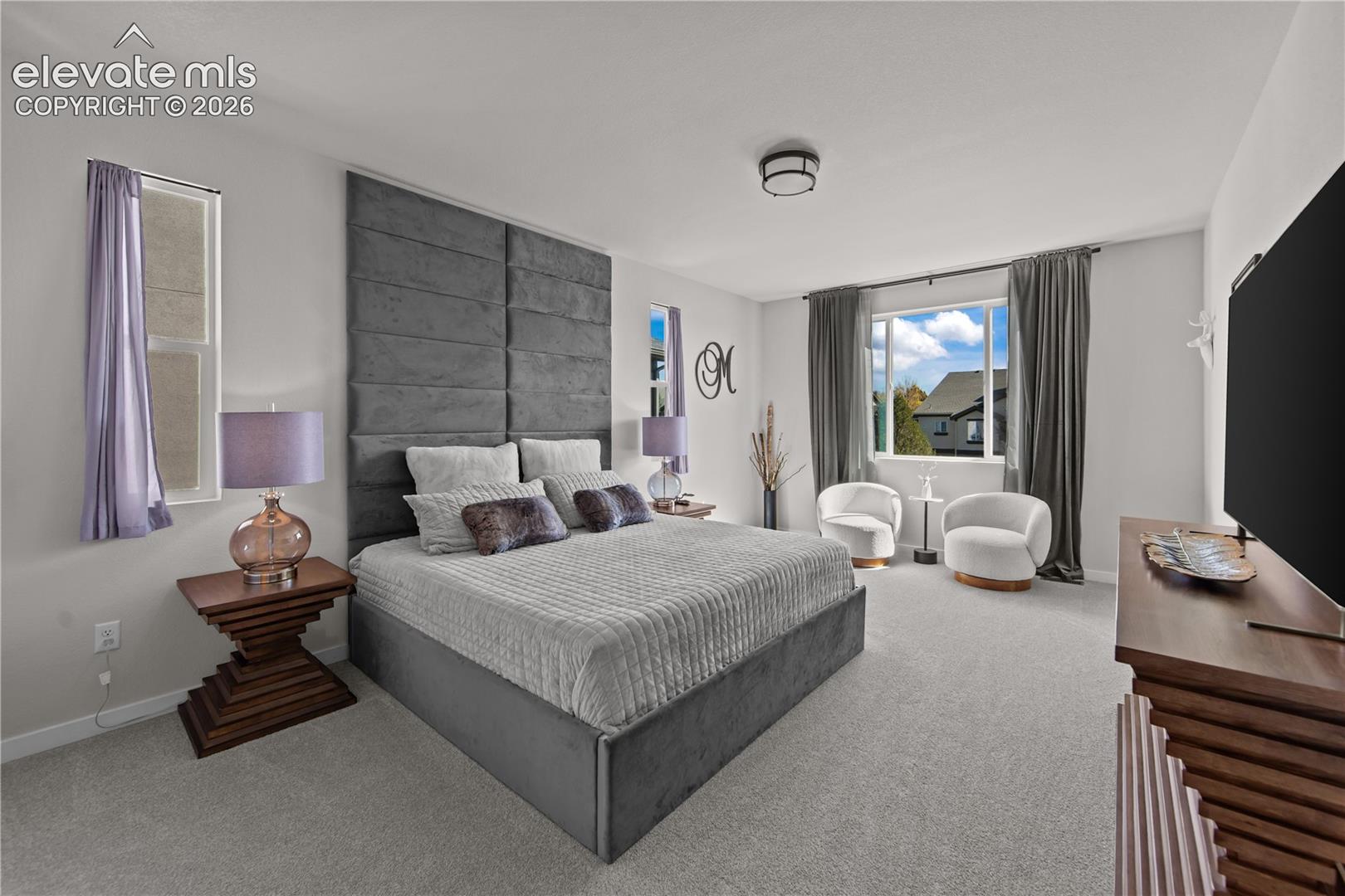 Neutral carpeting, custom floor-to-ceiling upholstered wall paneling, and a flush-mount ceiling light fixture