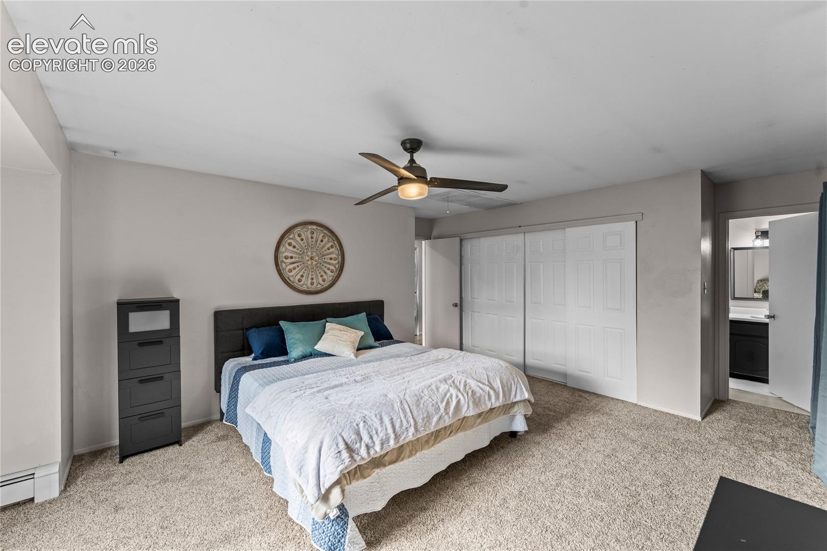 Bedroom featuring neutral wall paint, carpeted flooring, a ceiling fan with integrated lighting, and a dual-panel sliding closet