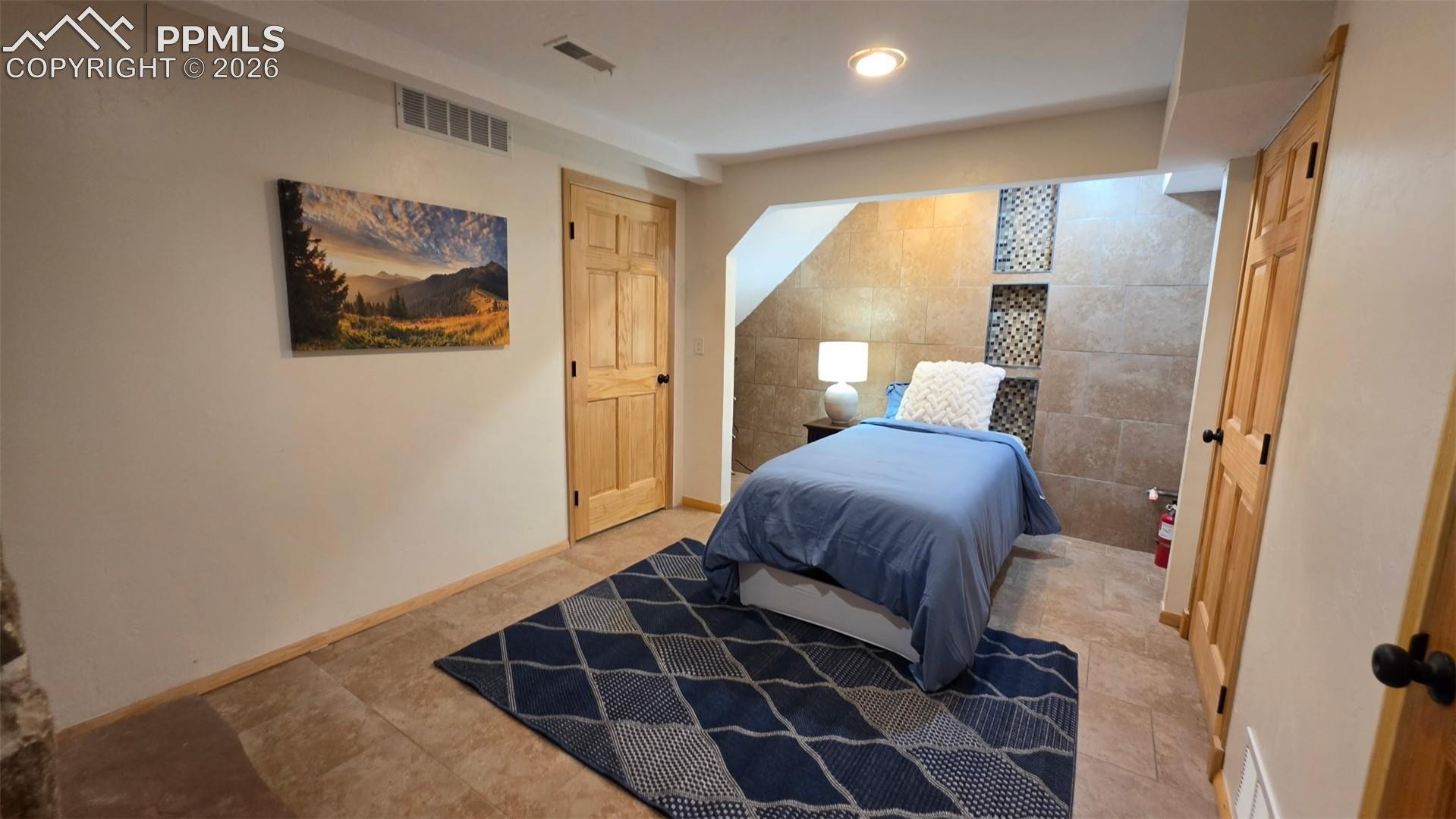 Bedroom with neutral wall paint and wood-finish doors