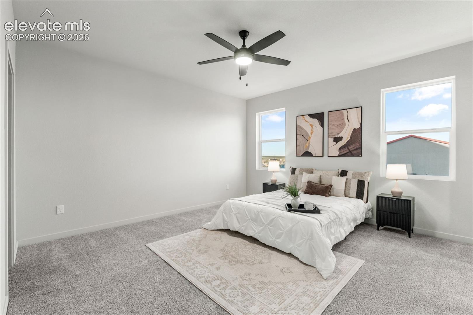 Neutral-toned carpeting, dual windows, and a ceiling fan with integrated lighting