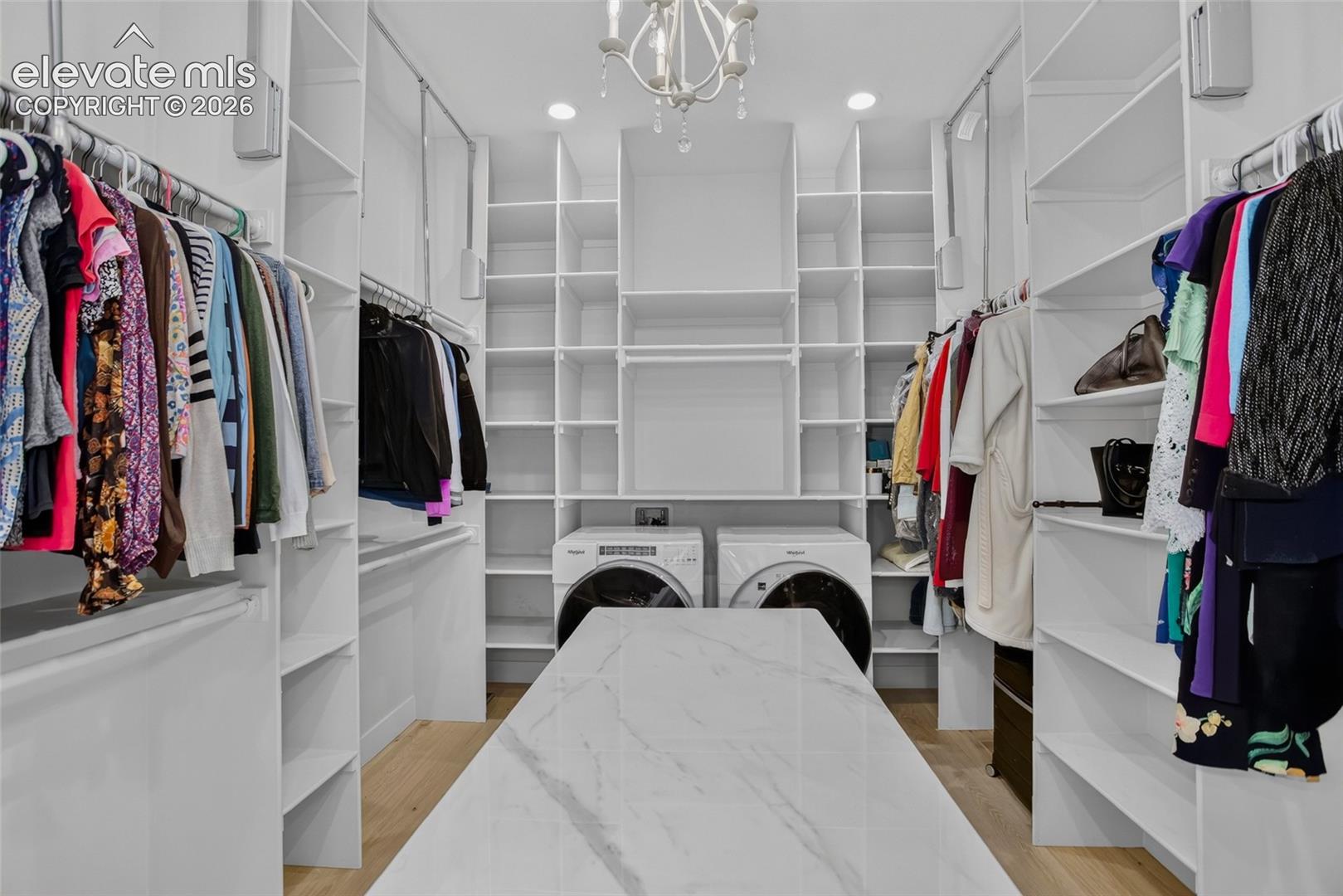 Primary closet - packing island, pull down rods, & dedicated laundry