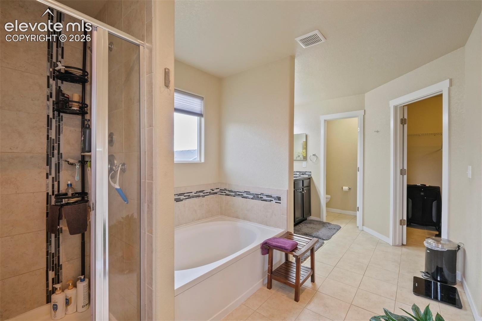 Upper Level: Tiled flooring and light-toned walls throughout this bathroom