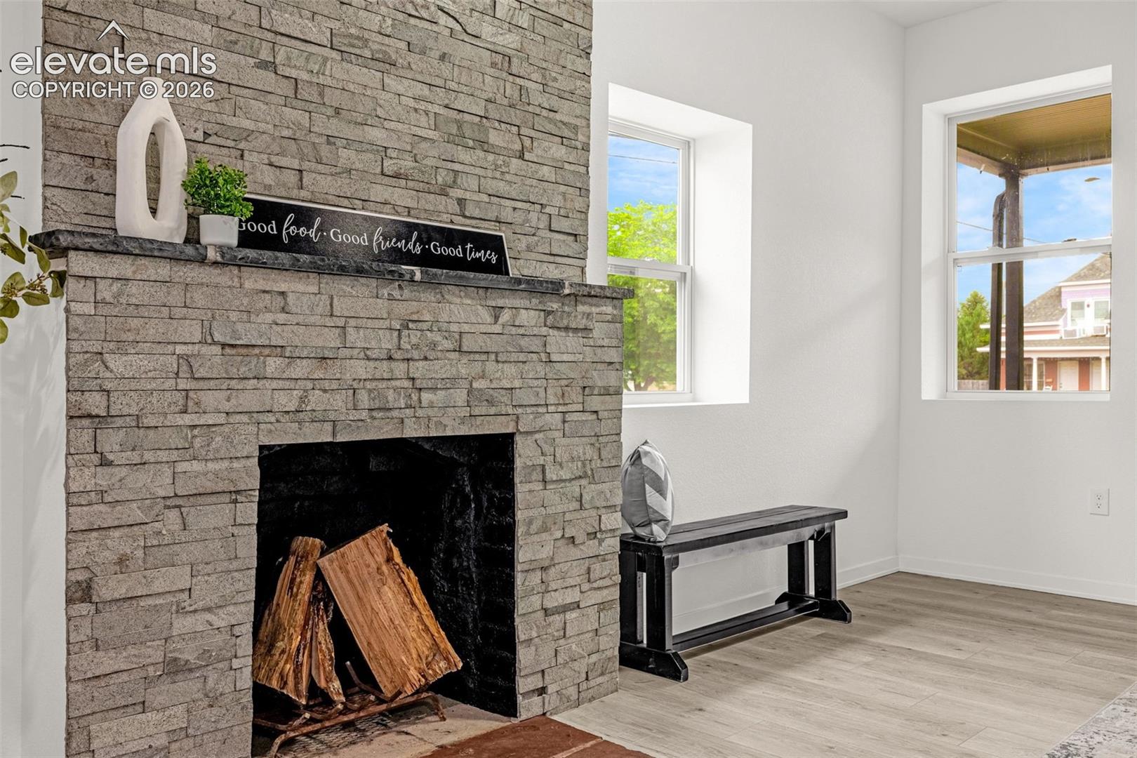 Stone-clad fireplace with a dark mantel, featuring a firebox and hearth