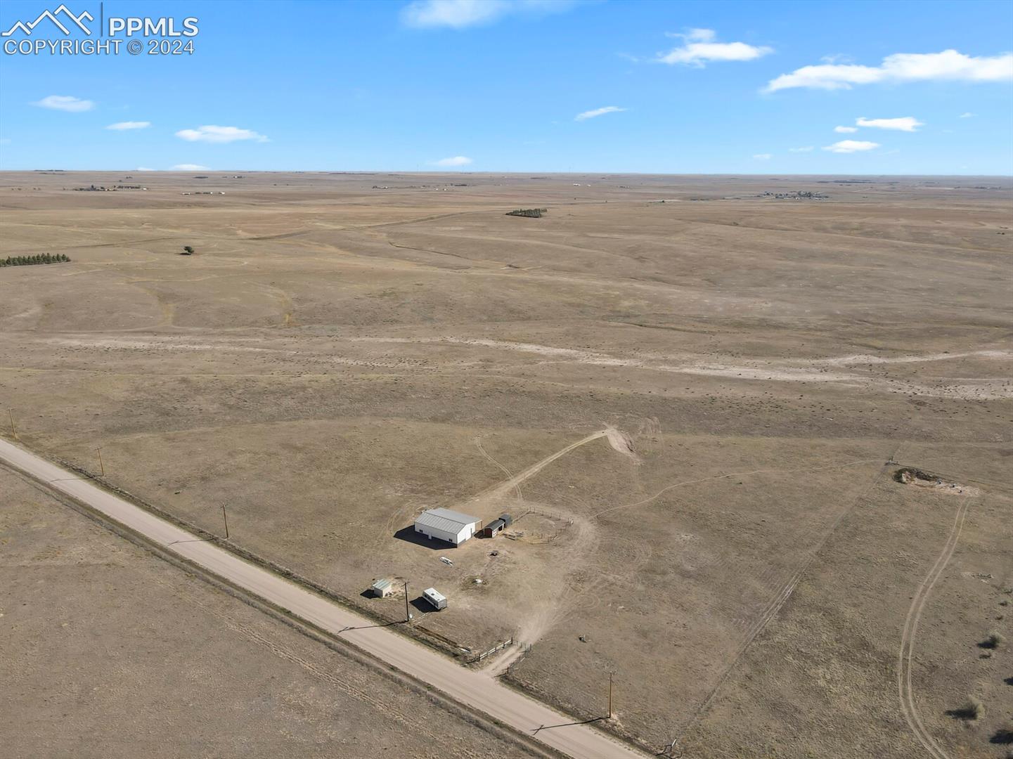 Expansive aerial view showing the scale and openness of the property