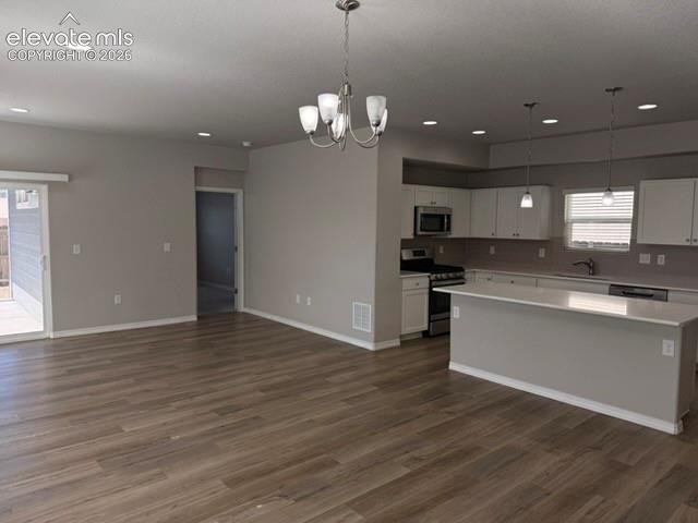 Open-concept living space featuring wood-finish flooring, recessed lighting, and a sliding glass door