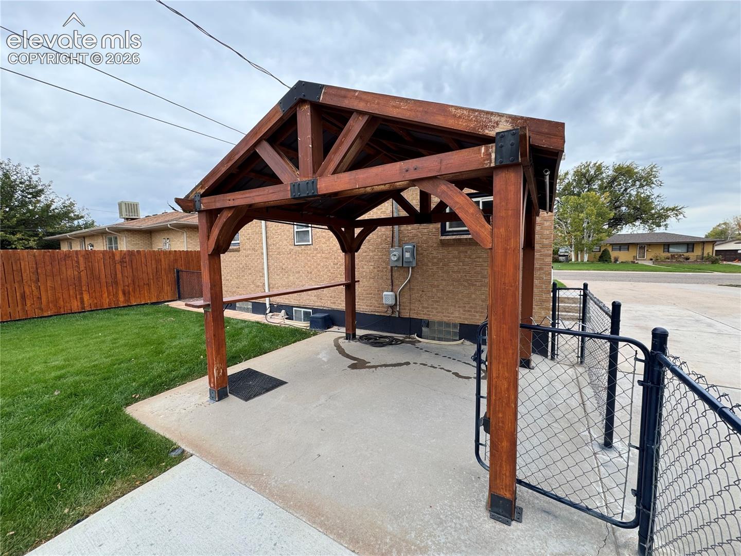 Timber-frame pavilion featuring a gable roof, metal support brackets, and an integrated counter