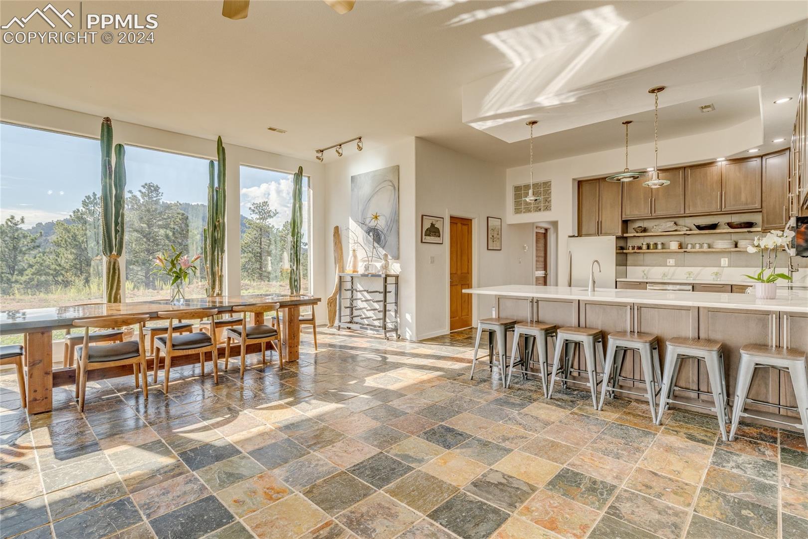 Dining room featuring sink, ceiling fan, rail lighting, and dark tile flooring