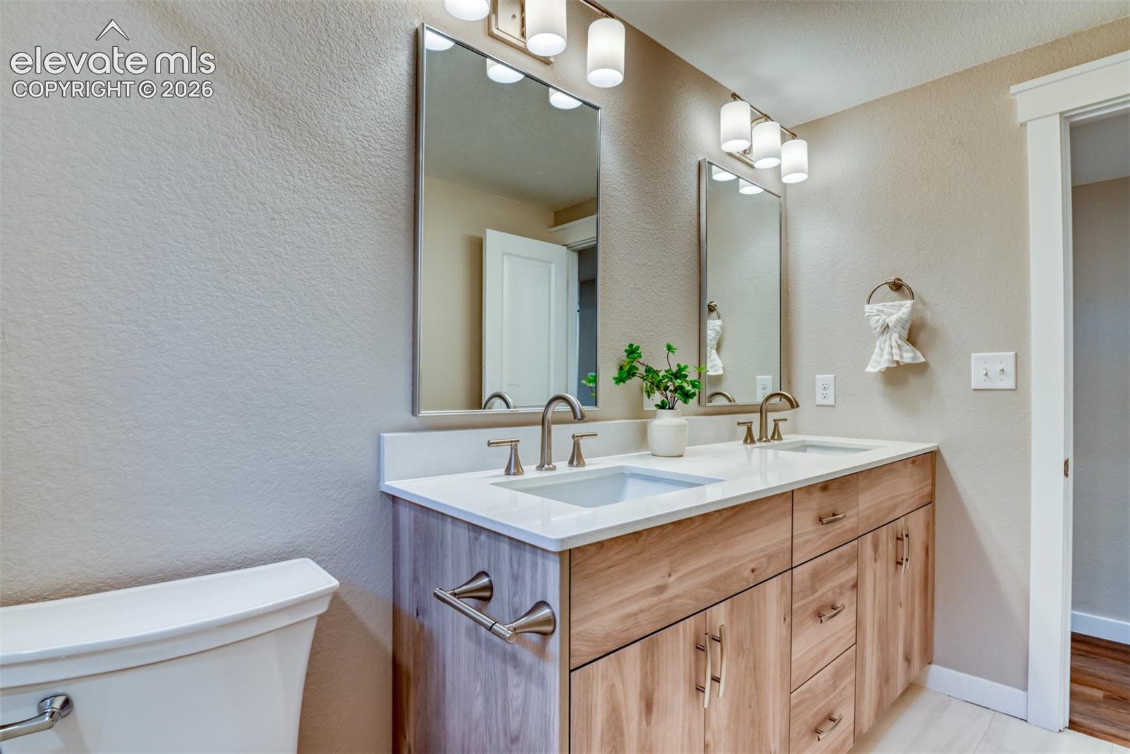 Dual vanity with wood-finish cabinetry and brushed nickel hardware