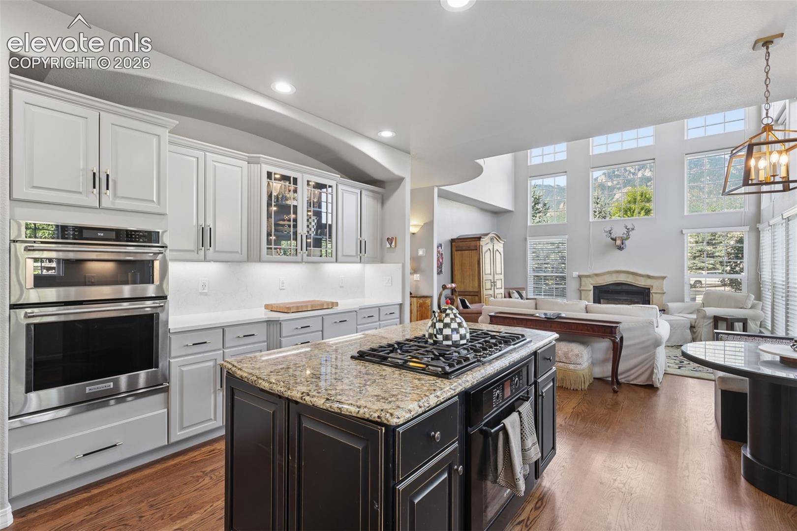 Beautifully remodeled gourmet kitchen with granite, quartz, wood floors, island, and high-end appliances.