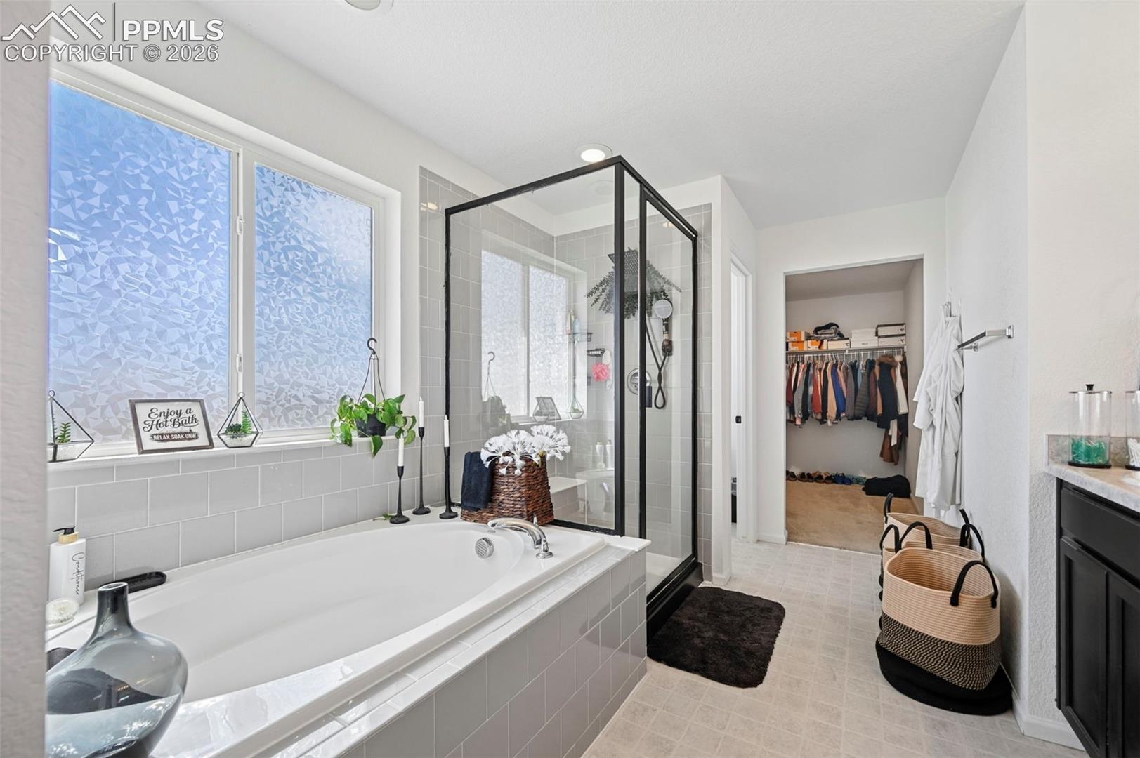 Deep soaking tub with light gray subway tile surround