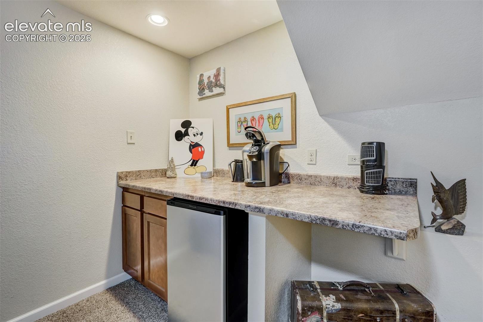 Built-in cabinetry with a countertop, integrated compact refrigerator, and recessed lighting