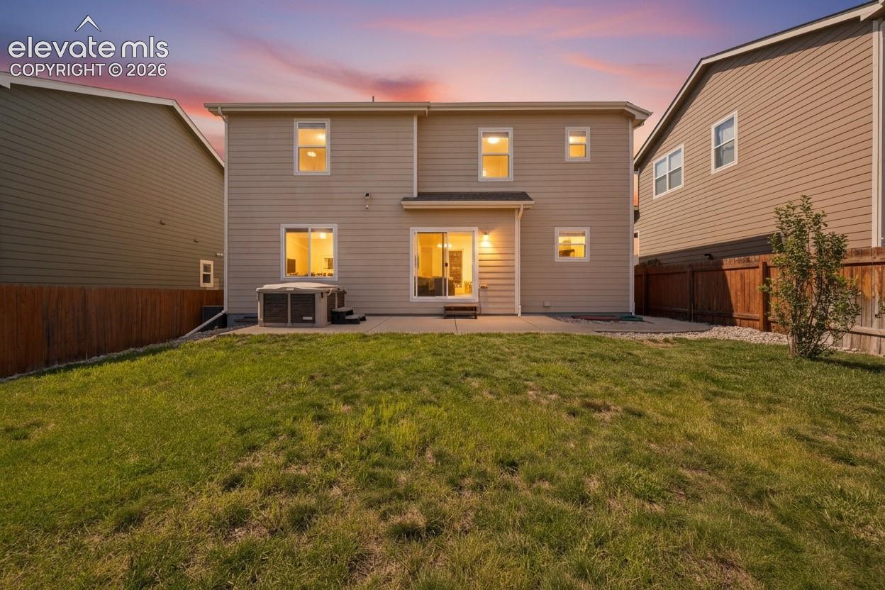 Fenced backyard, and a hot tub, green grass