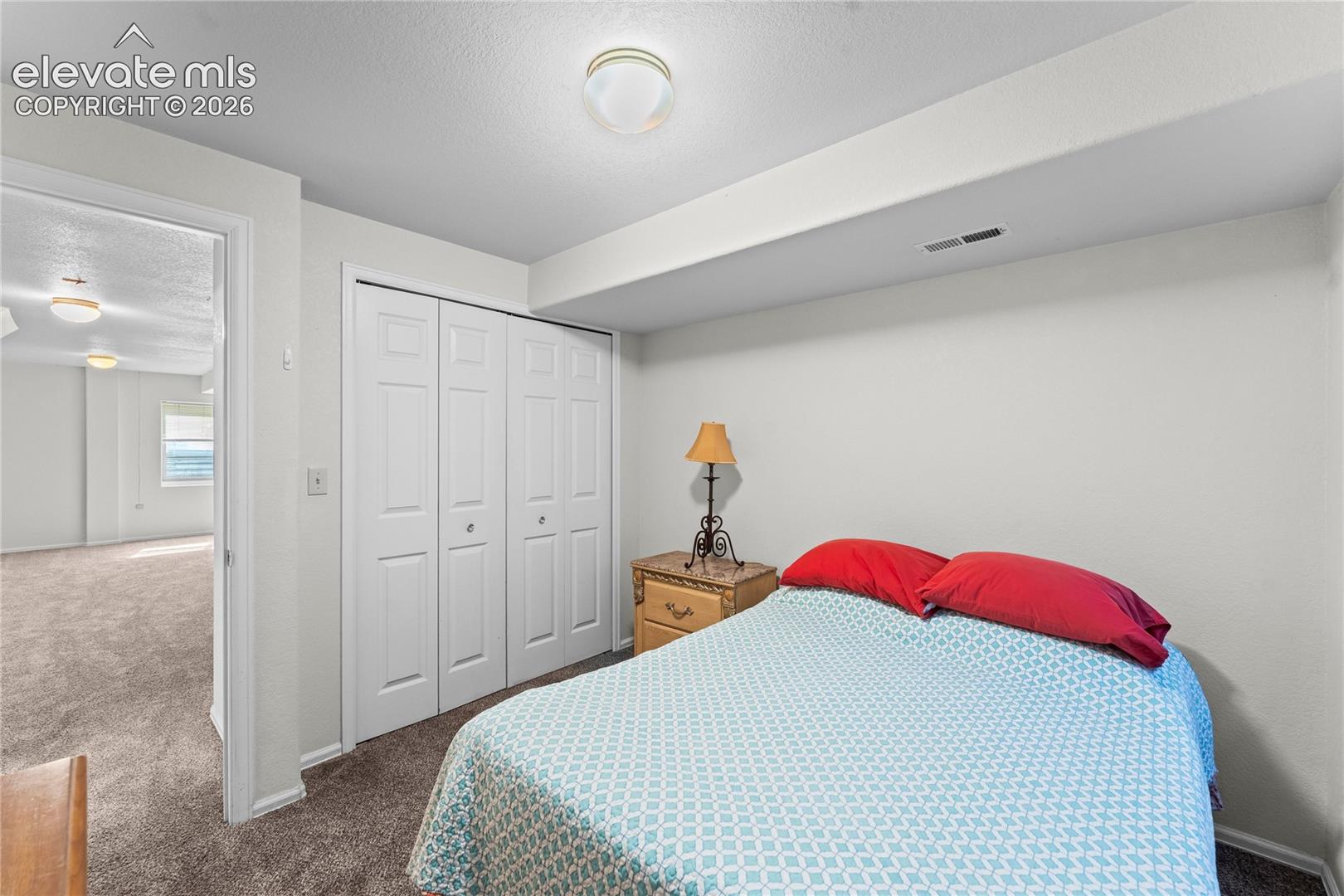 Neutral wall paint, recessed lighting, bi-fold closet doors, and carpet flooring