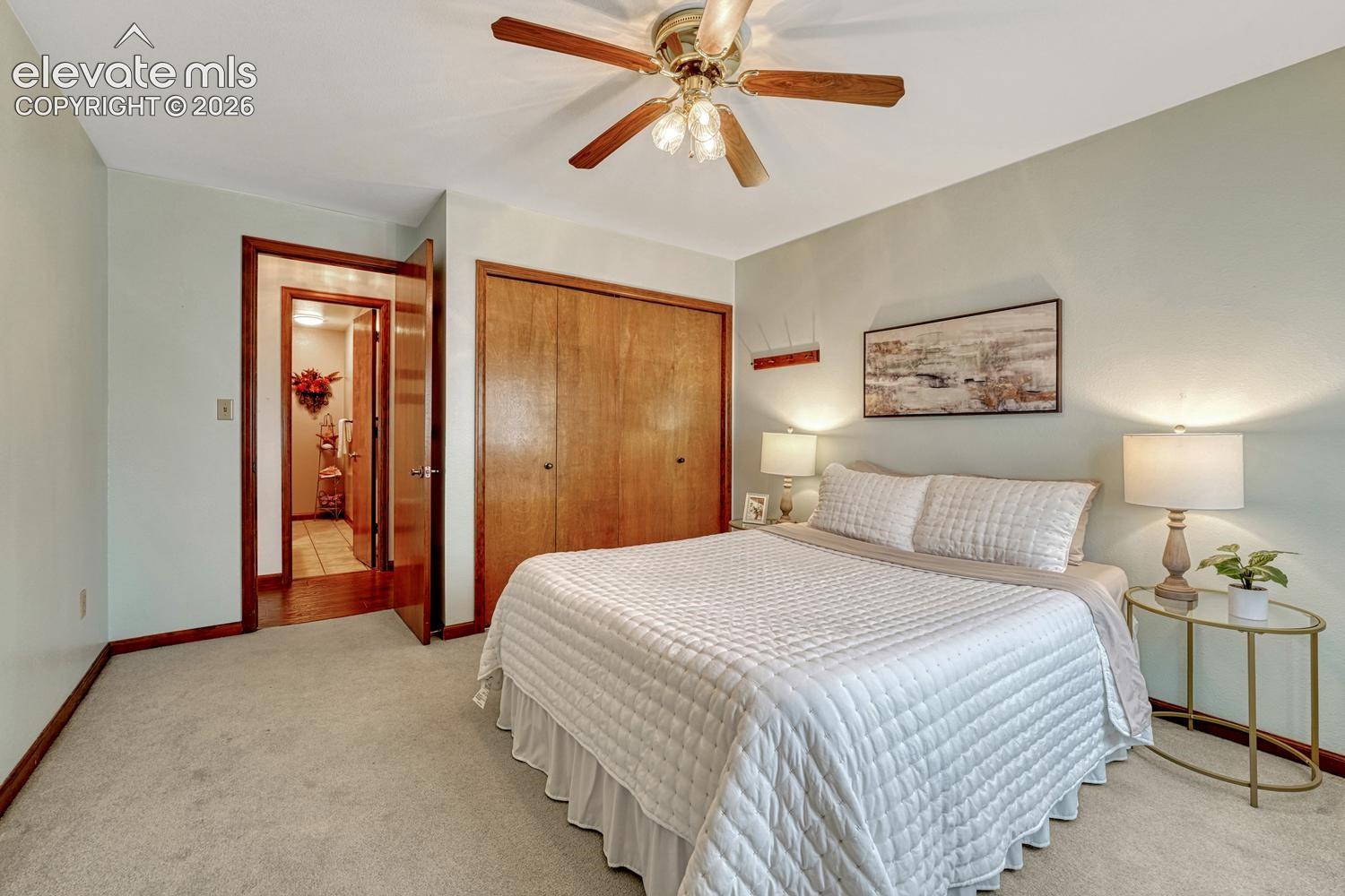 Upper Level Bedroom with carpet and lighted ceiling fan.