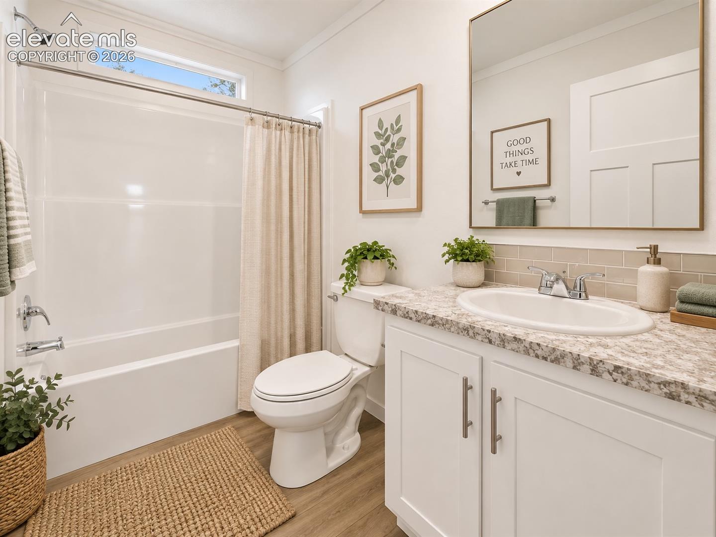 Full Bathroom – Bright full bath features a tub-and-shower combination, stone-look vanity countertop, tile backsplash, and a transom window for added natural light.
