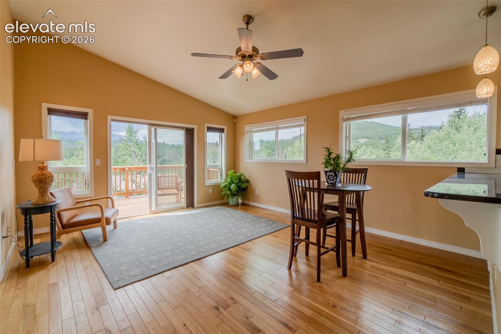 Comfortable family room with oversized windows showcasing the surrounding scenery and easy access to the kitchen.