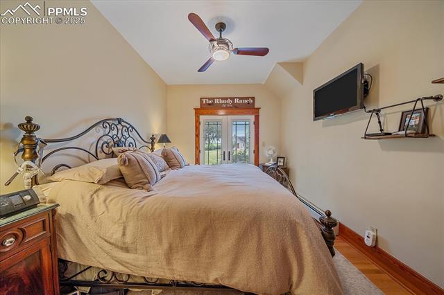 Bedroom featuring access to exterior, wood finished floors, and ceiling fan