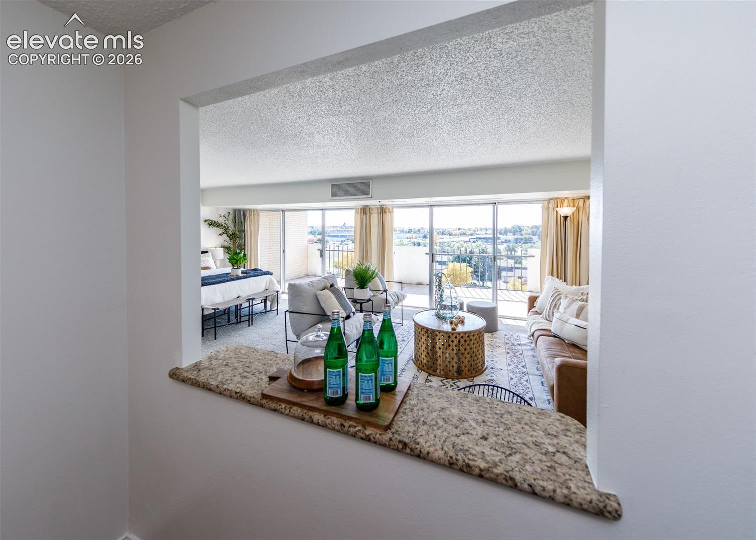 Pass-through window featuring a stone countertop, floor-to-ceiling sliding glass doors, and a private balcony