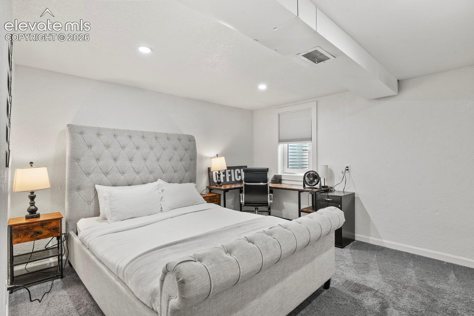 Basement bedroom with small office area and egress window installed to code.