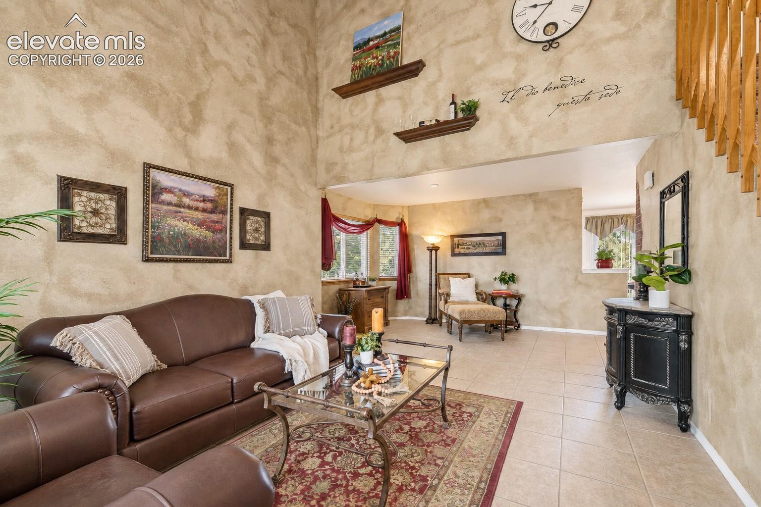 The Formal Living Room features tile flooring, textured walls, soaring ceilings and a cozy sitting area with bay window