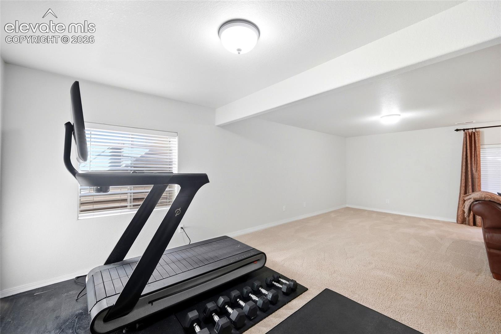 Spacious room with recessed lighting and neutral carpeting